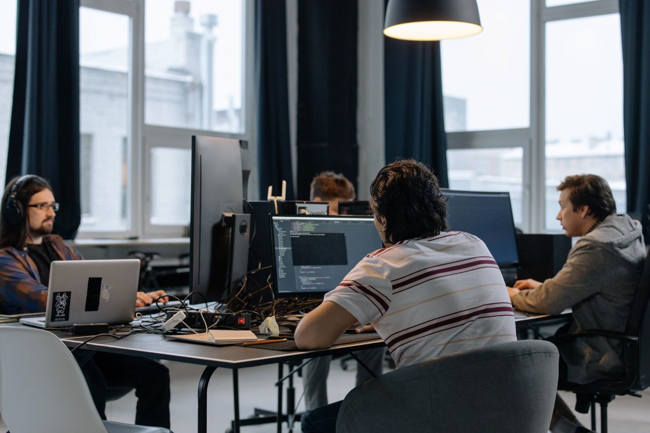 A team collaborating around a desk of documents and laptops