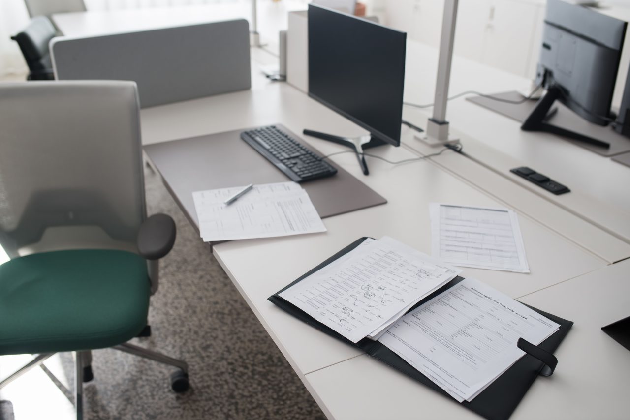 Application documents and a folder laid out on an office desk.